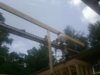Carpenter setting a ridge beam over a new addition frame — Ice Dam Removal by Roofing Brothers in Mooseheart