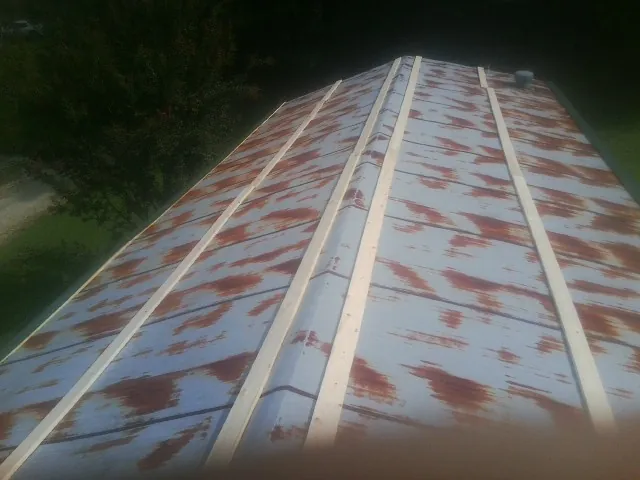 Rusted metal roof panels with new wood purlins before replacement — Storm Damage Roof Repair in Mooseheart by Roofing Brothers