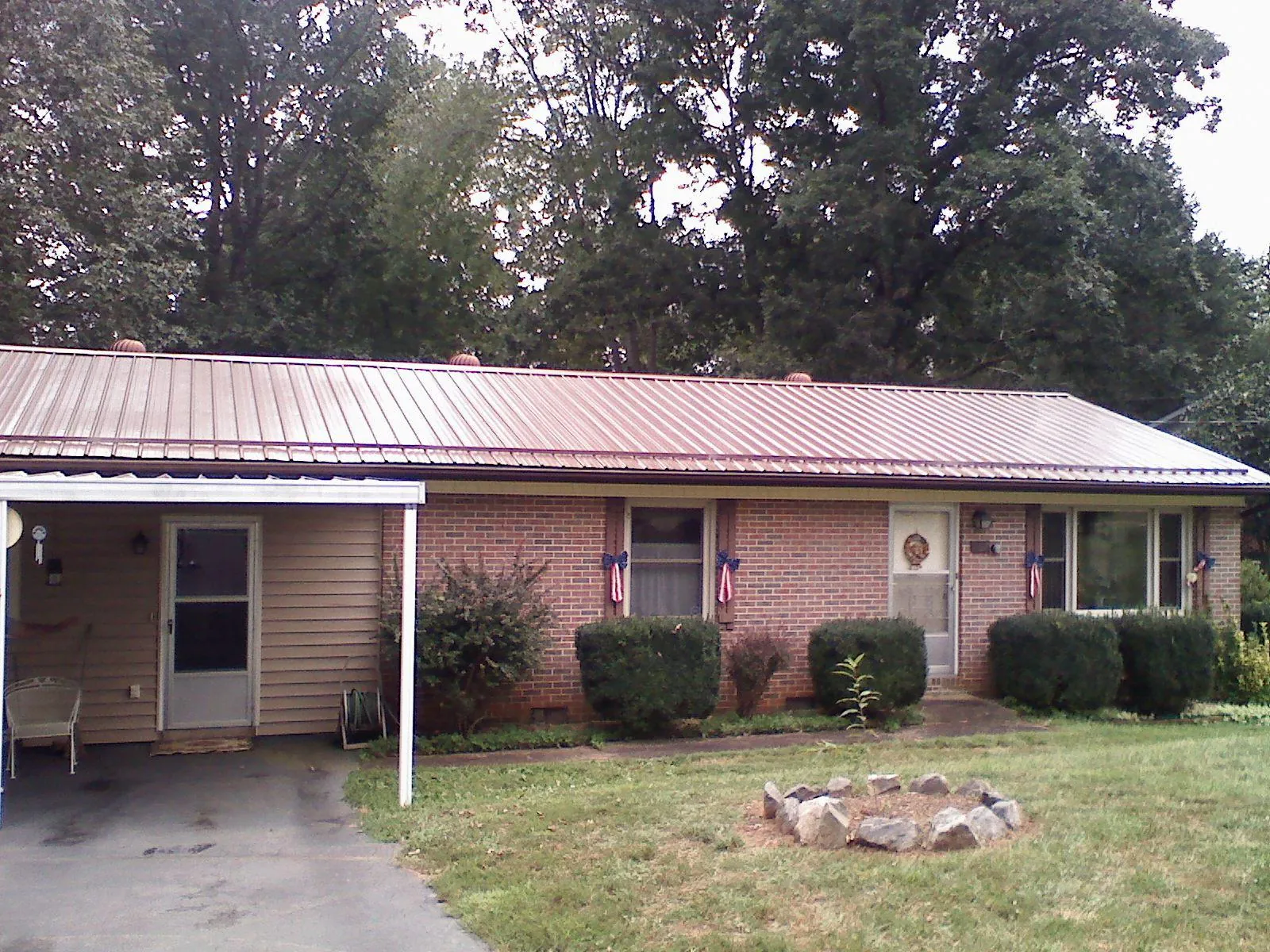 Bronze metal roof and carport on a brick ranch home — Roof Repair work by our crew in Mooseheart