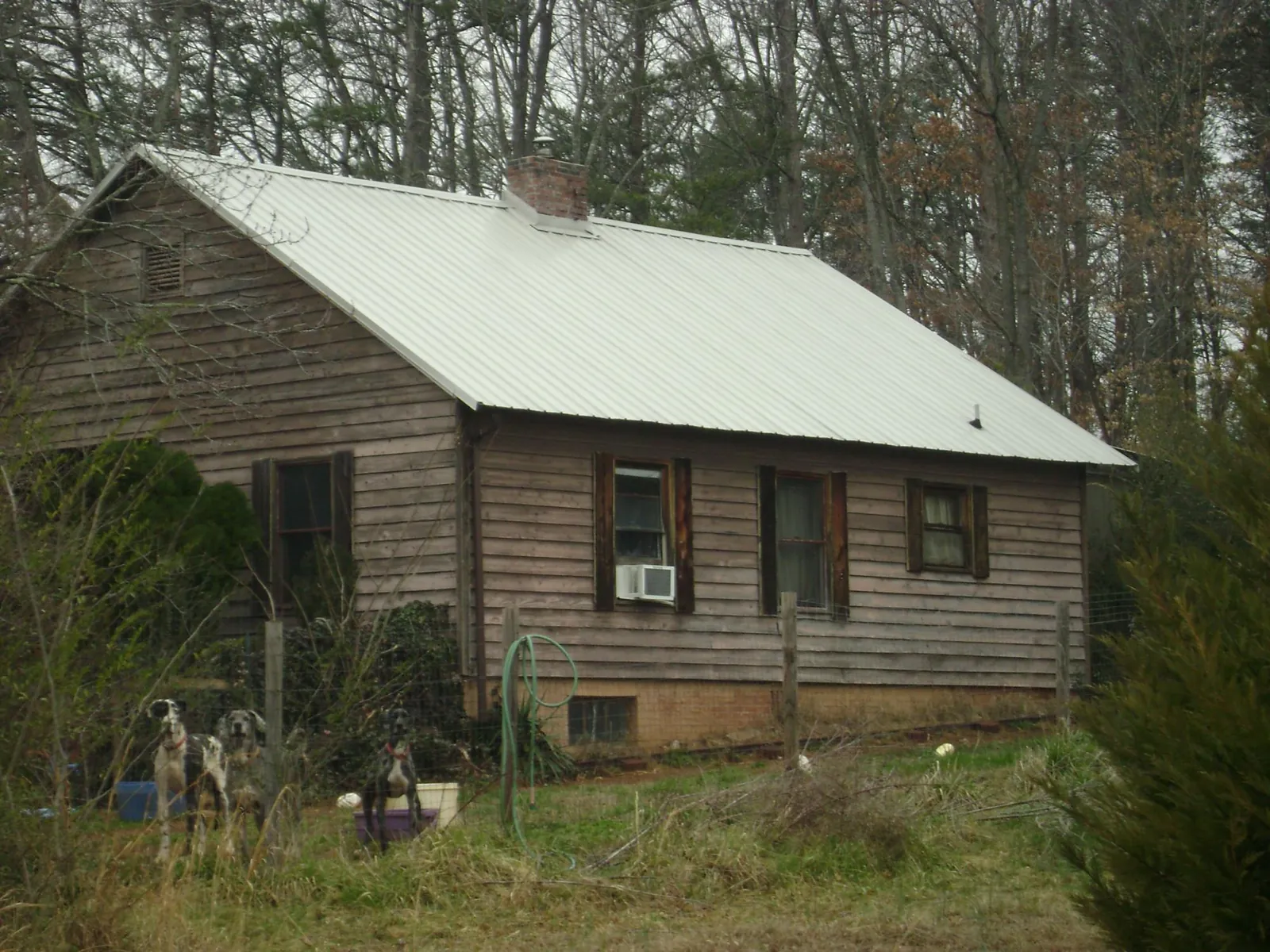 White metal roof on an old wood sided farmhouse, from a Metal Roof Installation job in Mooseheart